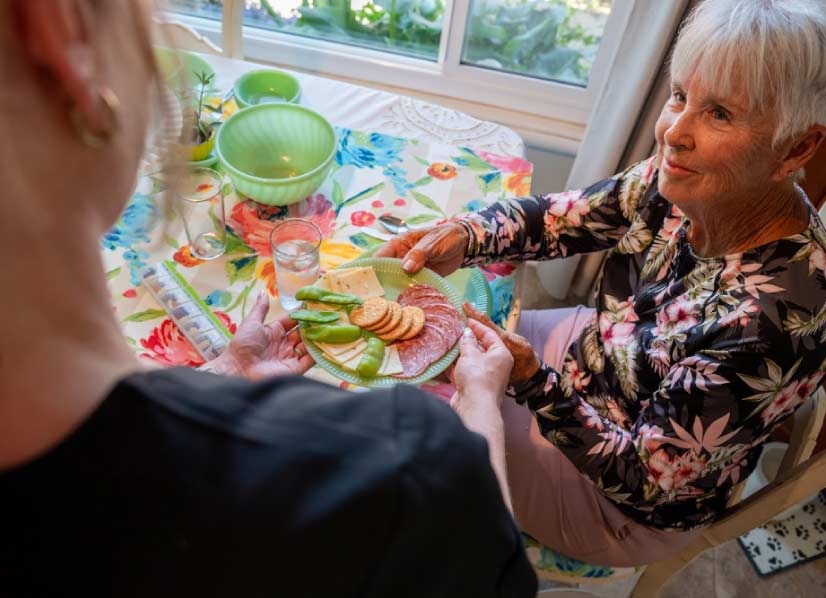 Caregiver and senior playing a board game for social engagement and companion care in tulare californa